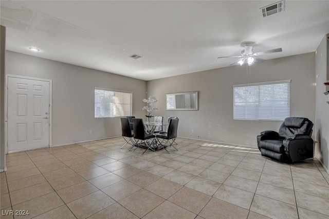 unfurnished dining area featuring light tile patterned floors and ceiling fan