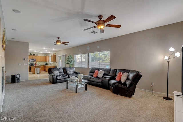 living area with a ceiling fan, light carpet, visible vents, and baseboards