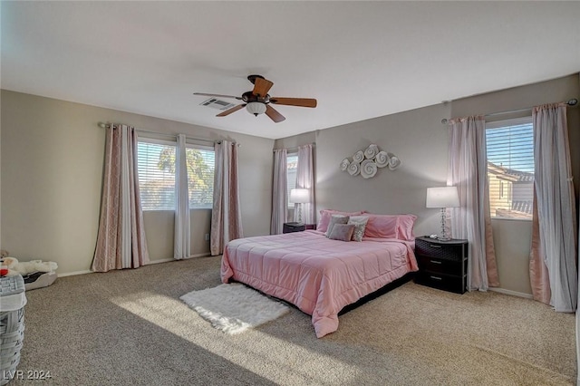 bedroom featuring baseboards, ceiling fan, visible vents, and light colored carpet