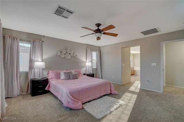 carpeted bedroom with baseboards, connected bathroom, and visible vents