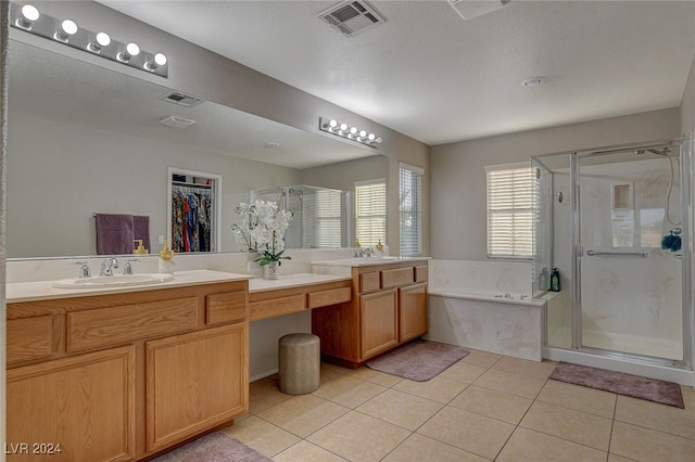 bathroom featuring separate shower and tub, tile patterned floors, vanity, and a textured ceiling