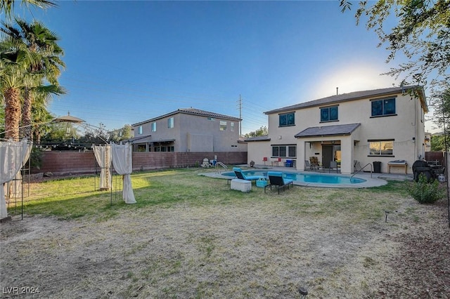 rear view of house with a patio, stucco siding, a fenced backyard, a yard, and a fenced in pool