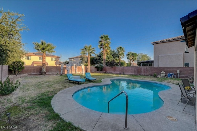 view of swimming pool featuring a yard, a fenced in pool, and a fenced backyard