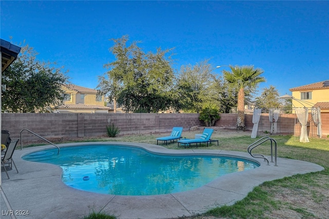 view of swimming pool with a lawn