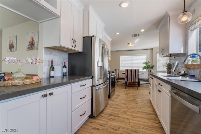 kitchen with stainless steel appliances, sink, and white cabinetry