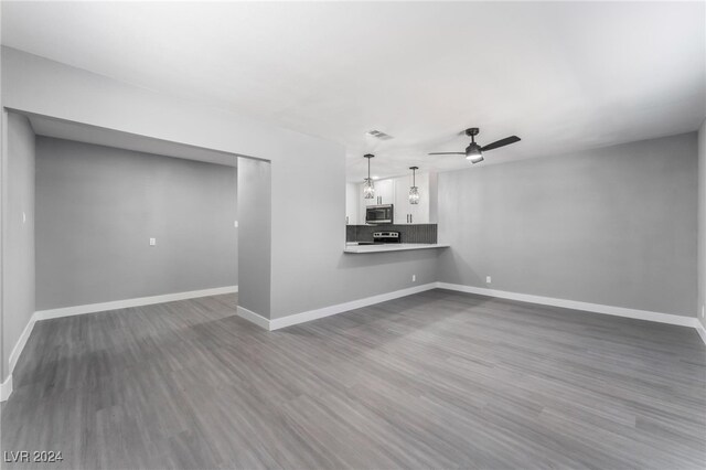 unfurnished living room featuring ceiling fan and hardwood / wood-style floors