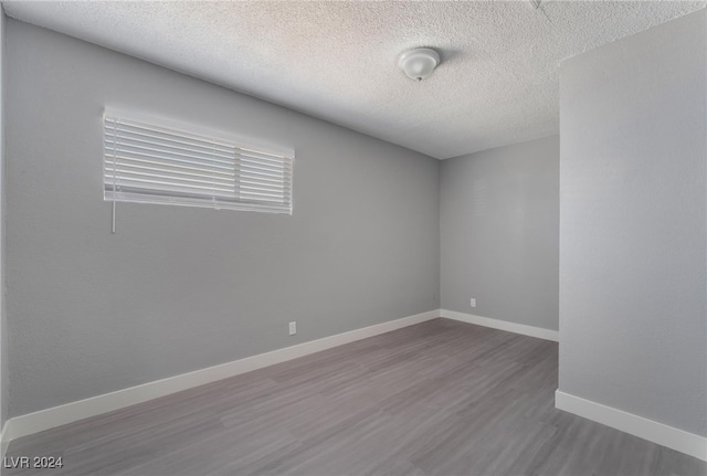 unfurnished room featuring hardwood / wood-style floors and a textured ceiling