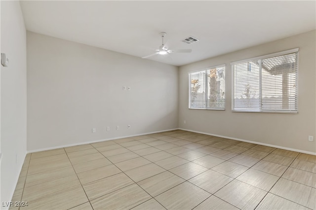 empty room with ceiling fan and light tile patterned floors