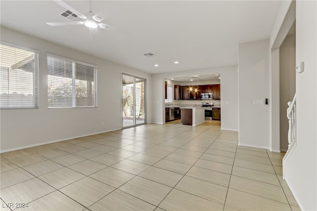 unfurnished living room featuring ceiling fan and light tile patterned floors