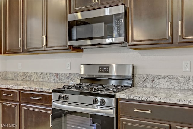 kitchen with tile patterned floors, appliances with stainless steel finishes, and dark brown cabinetry