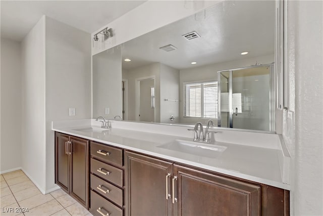 bathroom with vanity, tile patterned floors, and a shower with door