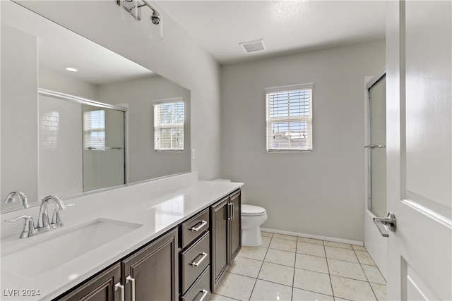 bathroom featuring vanity, a shower with shower door, toilet, and tile patterned flooring