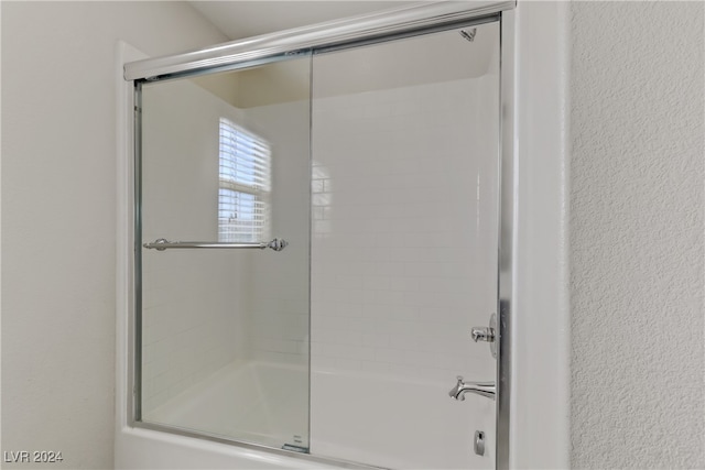 bathroom with combined bath / shower with glass door