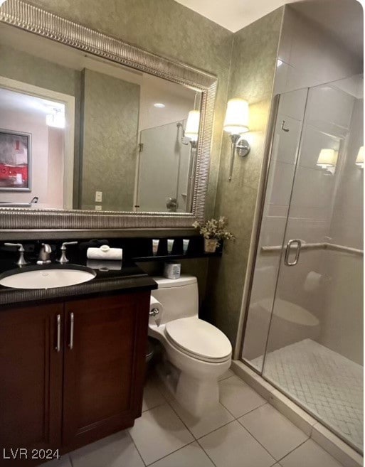 bathroom with tile patterned floors, vanity, a shower with door, and toilet