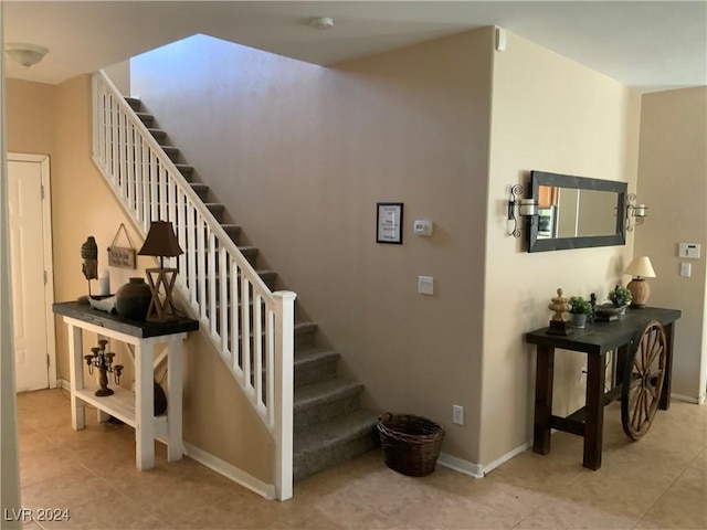 stairway with tile patterned floors and baseboards