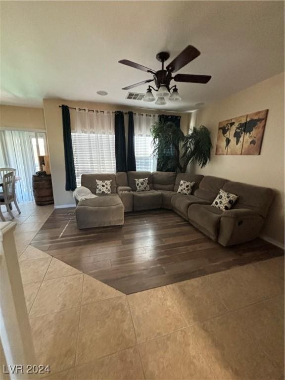 living area with baseboards, a ceiling fan, light tile patterned flooring, and visible vents