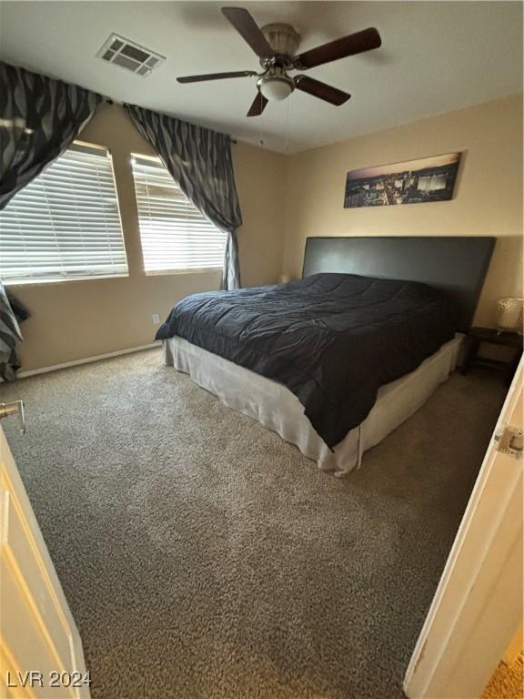 bedroom with baseboards, carpet, a ceiling fan, and visible vents