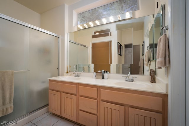 bathroom featuring vanity, a shower with shower door, and tile patterned flooring