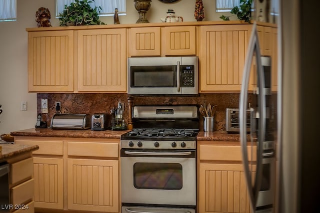 kitchen with light brown cabinets, appliances with stainless steel finishes, and backsplash