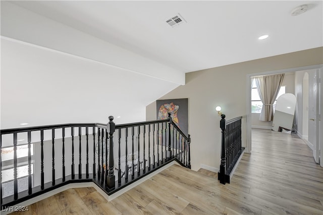 staircase featuring hardwood / wood-style floors and vaulted ceiling