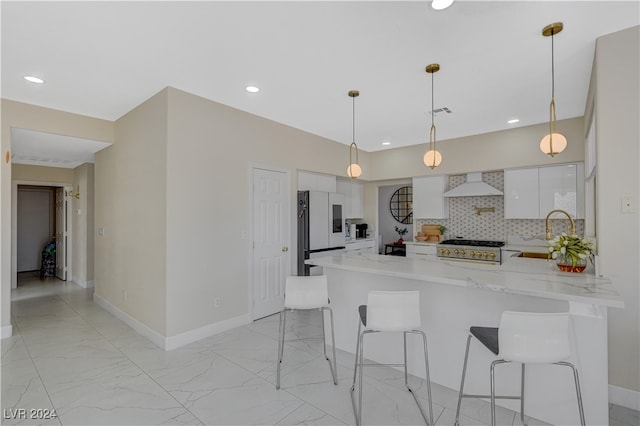 kitchen with custom exhaust hood, kitchen peninsula, white cabinets, decorative light fixtures, and white refrigerator