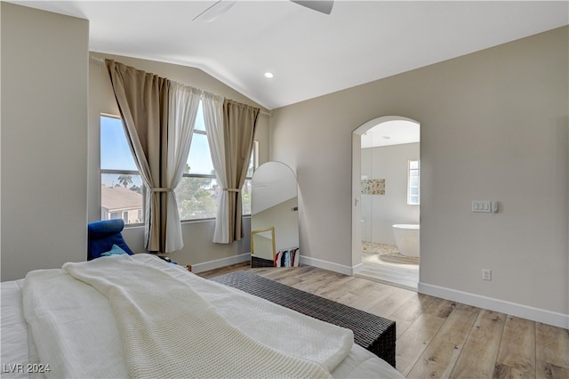 bedroom with vaulted ceiling, ensuite bathroom, light wood-type flooring, and ceiling fan