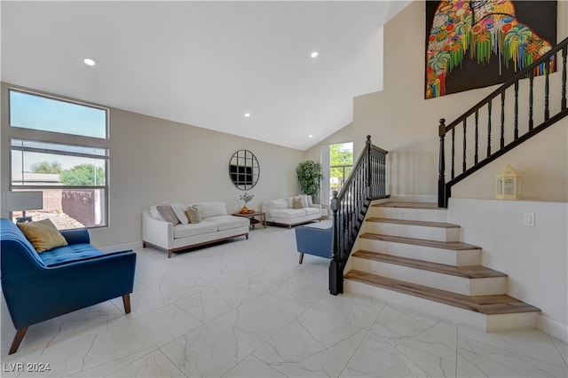 living room featuring high vaulted ceiling and a healthy amount of sunlight