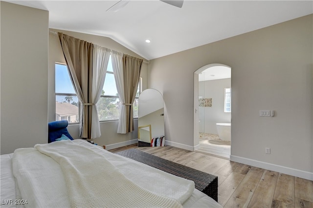 bedroom with light hardwood / wood-style floors, connected bathroom, vaulted ceiling, and ceiling fan