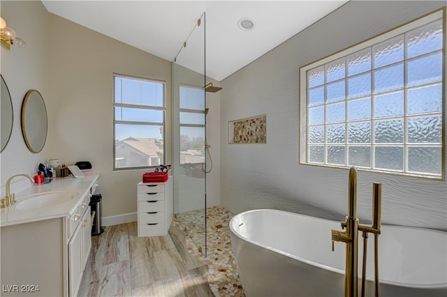 bathroom featuring vanity, independent shower and bath, wood-type flooring, and vaulted ceiling