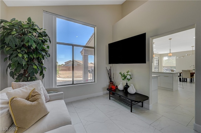 living room featuring a wealth of natural light and vaulted ceiling