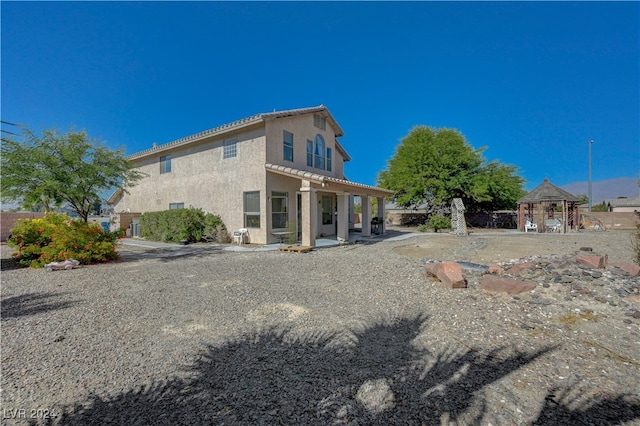 rear view of property with a gazebo and a patio