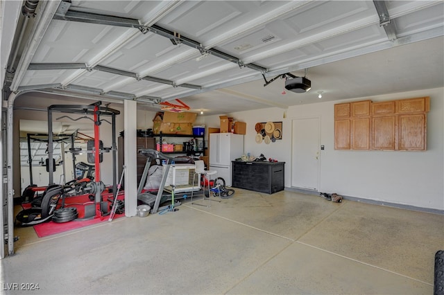 garage featuring a garage door opener and white fridge