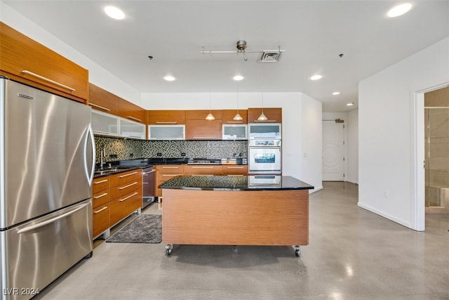 kitchen with hanging light fixtures, backsplash, appliances with stainless steel finishes, a center island, and a kitchen bar