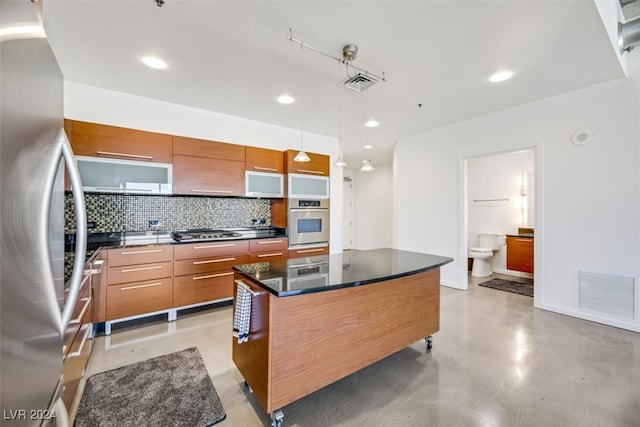 kitchen featuring stainless steel appliances, hanging light fixtures, backsplash, and a kitchen island