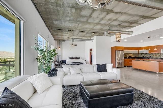 living room with ceiling fan and concrete floors