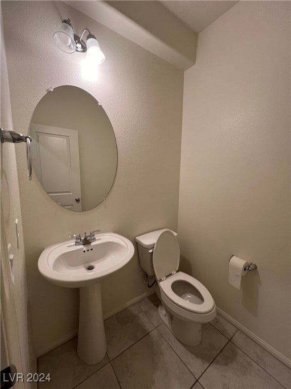 bathroom featuring sink, tile patterned floors, and toilet