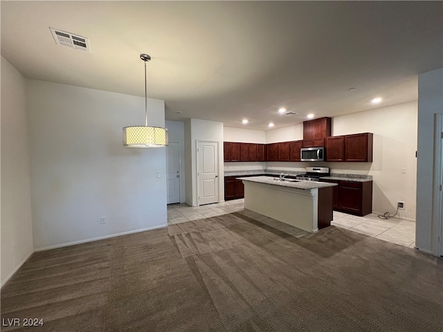 kitchen featuring sink, hanging light fixtures, a kitchen island with sink, stainless steel appliances, and light carpet