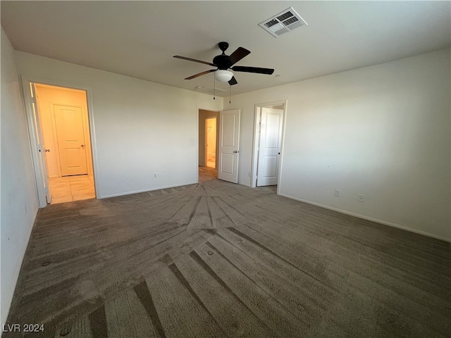 unfurnished bedroom with ceiling fan and dark carpet