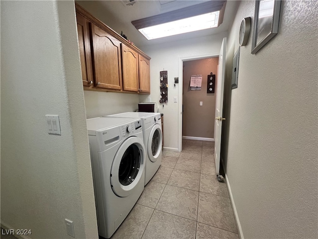 clothes washing area with light tile patterned floors, washer and clothes dryer, and cabinets