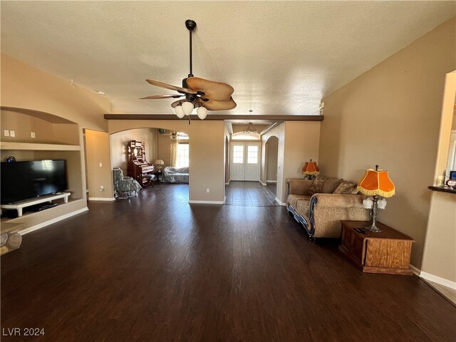 living room with dark wood-type flooring, a textured ceiling, and ceiling fan