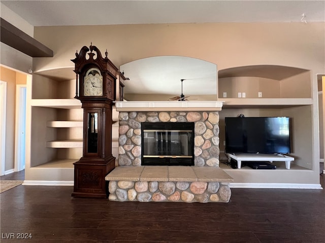 unfurnished living room with a fireplace, built in features, dark hardwood / wood-style floors, and ceiling fan