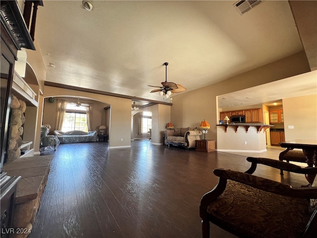 living room with ceiling fan and dark hardwood / wood-style flooring