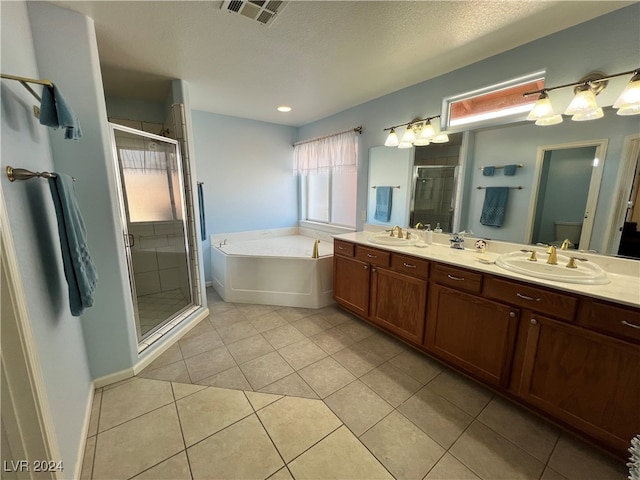 bathroom featuring vanity, plus walk in shower, tile patterned flooring, and a textured ceiling