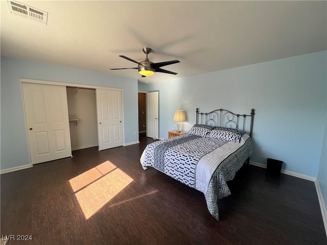 bedroom with dark hardwood / wood-style floors, ceiling fan, and a closet