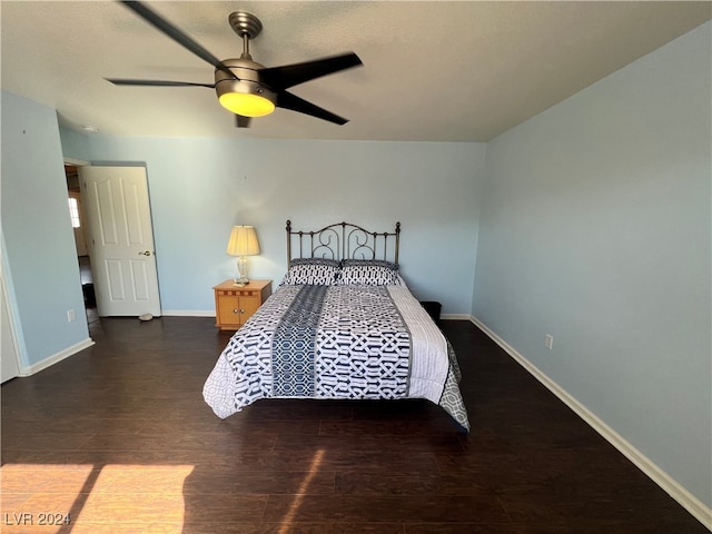 bedroom with dark hardwood / wood-style flooring and ceiling fan