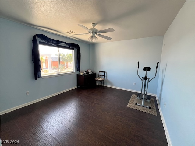 workout room featuring dark hardwood / wood-style floors, a textured ceiling, and ceiling fan