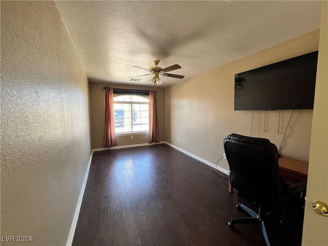 unfurnished office featuring a textured ceiling, dark hardwood / wood-style floors, and ceiling fan