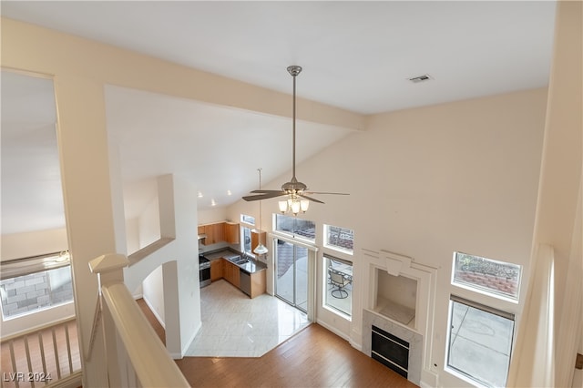 living room with ceiling fan, light wood-type flooring, and high vaulted ceiling