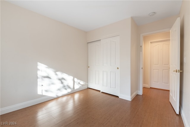 unfurnished bedroom featuring hardwood / wood-style flooring and a closet