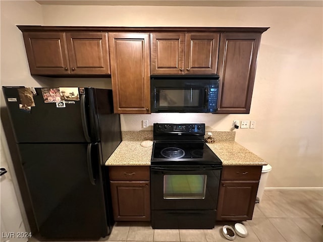 kitchen featuring light tile patterned floors, black appliances, and dark brown cabinetry